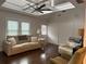 Cozy living room featuring a tray ceiling, plush seating, and natural light from windows at 6121 Gordy Ne St, Covington, GA 30014