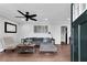 Inviting living room featuring hardwood floors, a cozy gray sofa, modern ceiling fan and natural light at 681 Home Se Ave, Atlanta, GA 30312