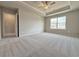 Large bedroom with tray ceiling, neutral carpet, and plenty of natural light at 1317 Fern Ridge Ct # 26, Norcross, GA 30093