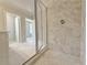 Walk-in shower features a glass door, stone-look tile, and tile shower floor at 1327 Fern Ridge Ct # 27, Norcross, GA 30093