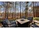 Outdoor entertaining area with stone fire pit and seating surrounded by tall trees at 2513 Overlake Ln, Stockbridge, GA 30281
