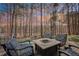 Outdoor entertaining area with stone fire pit and seating surrounded by tall trees at 2513 Overlake Ln, Stockbridge, GA 30281