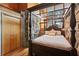 Charming bedroom with a four-poster bed, stone walls, hardwood floors, and large windows with natural light at 2513 Overlake Ln, Stockbridge, GA 30281