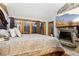 Spacious bedroom features a stone fireplace with a tv, wood floors, and glass doors to outside at 2513 Overlake Ln, Stockbridge, GA 30281
