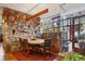 Open dining room features a stone wall, hardwood floors, glass walls, and a modern light fixture at 2513 Overlake Ln, Stockbridge, GA 30281