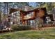 Wooded home featuring a wall of windows, a large, green yard, and mature trees at 2513 Overlake Ln, Stockbridge, GA 30281