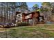 Wooded home featuring a wall of windows, a large, green yard, and mature trees at 2513 Overlake Ln, Stockbridge, GA 30281
