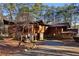 A rustic home featuring wood and stone elements, surrounded by lush greenery and a private driveway at 2513 Overlake Ln, Stockbridge, GA 30281