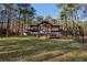 Wooded home featuring a wall of windows, a large, green yard, and mature trees at 2513 Overlake Ln, Stockbridge, GA 30281