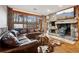 Cozy living room features a stone fireplace, hardwood floors, a leather sectional, and lots of natural light at 2513 Overlake Ln, Stockbridge, GA 30281