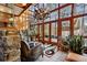 Bright sun room featuring a wood paneled ceiling, stone wall, tile floor, and picturesque views at 2513 Overlake Ln, Stockbridge, GA 30281