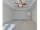 Bright primary bedroom with tray ceiling and a ceiling fan, showcasing a spacious layout and doorway access to hallway at 4118 Haleston Rd, Duluth, GA 30097