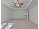 Bright primary bedroom with tray ceiling and a ceiling fan, showcasing a spacious layout and doorway access to hallway at 4118 Haleston Rd, Duluth, GA 30097