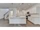 Modern kitchen with a large island, stainless steel appliances, and hardwood floors with stairs to the second story at 4118 Haleston Rd, Duluth, GA 30097