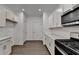 Clean kitchen features white cabinets, stainless appliances, and hardwood style flooring at 4118 Haleston Rd, Duluth, GA 30097