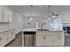 Open-concept kitchen with a stainless steel dishwasher, white cabinets, and views into the living area at 4118 Haleston Rd, Duluth, GA 30097