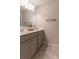 Bathroom with double sinks, a large mirror, and gray shaker cabinets on top of marble-look flooring at 4480 Sunflower Cir, Cumming, GA 30040