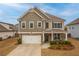 Charming two-story home featuring stone accents, a two-car garage, and a well-maintained front lawn at 4480 Sunflower Cir, Cumming, GA 30040