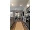 Modern kitchen featuring stainless steel appliances, gray cabinets, and a dining area with natural light at 4480 Sunflower Cir, Cumming, GA 30040