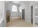 Bright bathroom featuring a tiled shower, soaking tub, and large window for natural light at 7290 Weber St, Atlanta, GA 30349