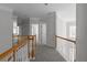Upstairs hallway featuring neutral carpet, white trim and railings with views of bedrooms and windows at 7290 Weber St, Atlanta, GA 30349
