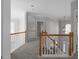 Hallway with grey carpet, white railings and trim leading to bedrooms and views to the foyer below at 7290 Weber St, Atlanta, GA 30349