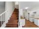 Staircase leading to a kitchen featuring butcher block counters, white cabinets and wood flooring at 2413 Charleston Pointe Ct, Atlanta, GA 30316