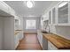 Bright kitchen with butcher block counters, white cabinets, stainless steel sink, and wood flooring at 2413 Charleston Pointe Ct, Atlanta, GA 30316