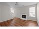 Cozy living room featuring fireplace, hardwood floors, and a large window for natural light at 2413 Charleston Pointe Ct, Atlanta, GA 30316