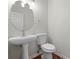 Powder room featuring pedestal sink, toilet, and round mirror at 2413 Charleston Pointe Ct, Atlanta, GA 30316