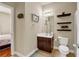 Well-lit bathroom with a vanity, decorative shelves, toilet, neutral walls and a view into the adjacent bedroom at 2468 Cannon Farm Ln, Duluth, GA 30097