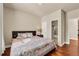 Cozy bedroom featuring hardwood floors, neutral walls, and a comfortable bed with a patterned quilt at 2468 Cannon Farm Ln, Duluth, GA 30097