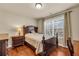 Cozy bedroom featuring a wooden bed frame, bedside table, and window at 2468 Cannon Farm Ln, Duluth, GA 30097