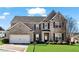 Charming brick home featuring manicured lawn, dark shutters, and attached two-car garage at 2468 Cannon Farm Ln, Duluth, GA 30097