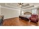 Expansive main bedroom featuring tray ceilings, hardwood floors, and a comfortable sitting area with a recliner at 2468 Cannon Farm Ln, Duluth, GA 30097