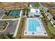 Aerial view of the swimming pool, tennis courts, clubhouse, and parking area in the community at 5360 Memento Trce, Cumming, GA 30040