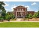 Beautifully landscaped grounds in front of an elegant brick building with columns and classic architectural design at 5360 Memento Trace, Cumming, GA 30040