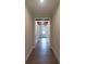 Long hallway with hardwood floors and decorative beams, leading to a bright doorway at 5360 Memento Trce, Cumming, GA 30040