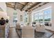 Inviting living room with wood beam ceilings, a decorative chandelier and a wall of windows at 5360 Memento Trce, Cumming, GA 30040