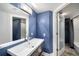 Stylish bathroom with modern fixtures, a blue accent wall, and a glass door to the shower at 199 14Th Ne St # 2407, Atlanta, GA 30309