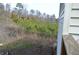 Side yard with wooden fencing, and grass surrounded by a wooded area at 2100 Driftwood Cir, Cumming, GA 30041