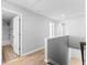 Upstairs hallway with hardwood flooring, a doorway to a bathroom, and stairs at 332 Meeting St, Mcdonough, GA 30252