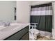 Well-lit bathroom featuring a vanity with sink and a shower with striped shower curtain at 5036 Longview Walk, Decatur, GA 30035
