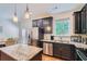 Modern kitchen featuring stainless steel appliances, granite countertops, and dark cabinetry at 5036 Longview Walk, Decatur, GA 30035
