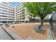 A fenced dog park featuring wood chip ground cover, benches, shade trees and a dog waste disposal station at 878 Peachtree Ne St # 608, Atlanta, GA 30309