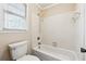 Bathroom featuring a shower-tub combo with white tiled surround and neutral paint at 220 Mimosa Dr, Fayetteville, GA 30214