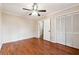 Bedroom with wood-look flooring, ceiling fan, and closet with bi-fold doors at 220 Mimosa Dr, Fayetteville, GA 30214