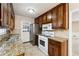 Galley kitchen with dark wood cabinets, granite counters, stainless steel appliances, and tiled backsplash at 220 Mimosa Dr, Fayetteville, GA 30214