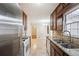 Kitchen featuring dark wood cabinetry, stainless steel appliances, and granite countertops at 220 Mimosa Dr, Fayetteville, GA 30214