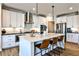 Well-lit kitchen boasts stainless appliances, white cabinetry, a large island, and stylish pendant lighting at 108 Fieldbrook Xing, Holly Springs, GA 30115